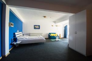 茨雷沃Family Hotel Four Seasons Tsarevo的一间卧室设有一张床和蓝色的墙壁