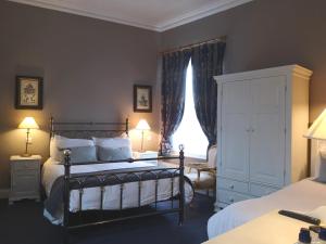都柏林欧尼尔斯维多利亚酒吧及联排别墅酒店的一间卧室配有一张床、一个梳妆台和一扇窗户。