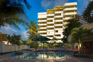 辛普森湾Atrium Beach Resort and Spa St Maarten a Ramada by Wyndham的大楼前设有游泳池的酒店