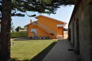 格罗韦CASA AUREA DE CACHEIRAS的院子中一座黄色的房子,有楼梯