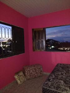 圣塔伦Guaraná da Cláudia的卧室设有粉红色的墙壁、一张床和窗户