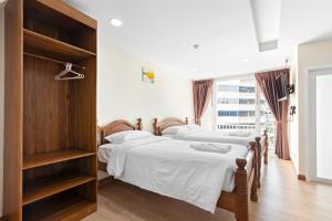 曼谷Royale 8 Ville Guest House的带窗户的客房内设有两张单人床。