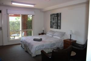 博士山Box Hill Studio Apartment 2的一间卧室设有一张大床和一个窗户。