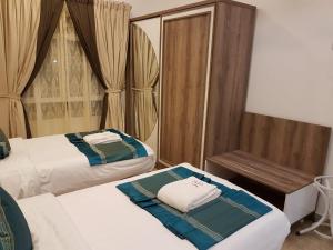 尼兹瓦Orient Apartments的酒店客房带两张床和长凳