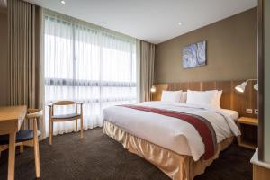 台北洛碁大饭店南港馆的酒店客房设有一张大床和一张书桌。