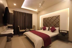 艾哈迈达巴德Hotel Flair Inn的酒店客房设有一张大床和一张书桌。