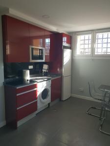 马德里WindRose 0的一间带红色橱柜和洗衣机的厨房