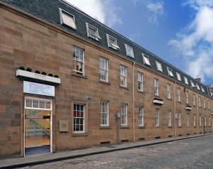 爱丁堡Stewart by Heeton Concept - Aparthotel Edinburgh的街道上带窗户的大型砖砌建筑