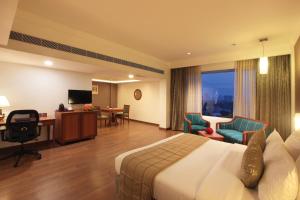 科钦Monsoon Empress Kochi的酒店客房,配有一张床、一张桌子和椅子