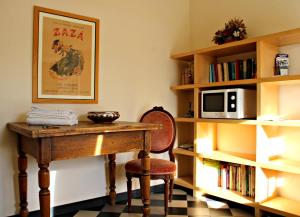 卡萨尔扎利古雷I Fiori di Miranda的一间设有桌子、微波炉和书架的房间