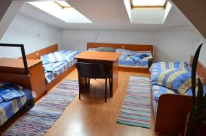 克卢日-纳波卡Kollege Hostel的宿舍间设有两张床和一张桌子及椅子。