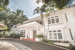 雅加达Capital O 332 Residence G17 Kemang的一座棕榈树掩映的白色房子