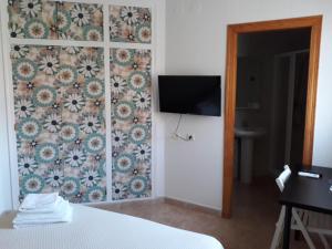 卡拉芭蒂纳Miramar Habitaciones的一间卧室设有一面墙壁,其中配有电视