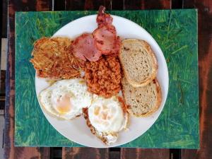 比勒陀利亚Home @ Harry's的包括鸡蛋培根和面包的早餐食品