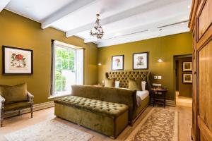 斯泰伦博斯兰兹拉卡酒店加Spa的一间卧室配有一张床、一张沙发和一个窗口