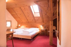 Kirchberg托根博格霍夫酒店的木制阁楼上的卧室配有两张床
