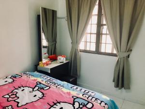 马六甲巴克卡迪因达旅舍的一间卧室配有一张床、牛被和窗户