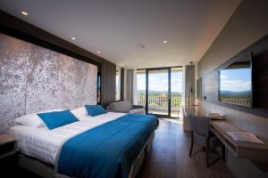 波斯托伊纳贾马酒店的酒店客房设有一张床、一张书桌和窗户。