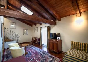 科斯蒂廖莱萨卢佐罗索城堡酒店的一间带床和电视的客厅