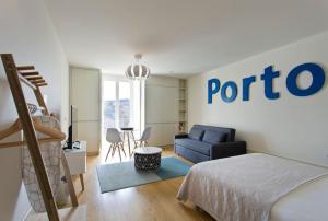 波尔图Vitoria Studio Residence - Downtown的一间卧室配有一张床和一张蓝色的沙发