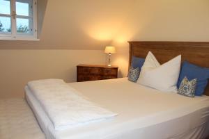 Sankt Anna am AigenBurgunderhof - Steiermark的卧室配有带蓝色枕头的大型白色床
