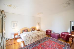 科斯蒂廖莱萨卢佐罗索城堡酒店的一间卧室配有床、两把椅子和地毯