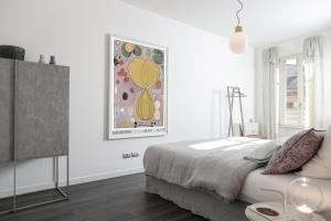 特伦托Manciuno的卧室配有一张床,墙上挂有绘画作品