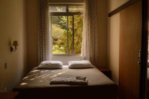 库里提巴贝塔尼亚旅馆的窗户客房内的一张床位
