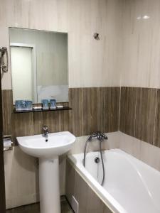 土城区土城飯店的浴室配有盥洗盆、浴缸和镜子