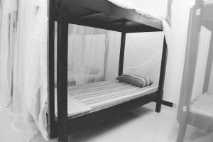 希克杜沃Hikka Surf Hostel的一张黑色双层床,上面有枕头