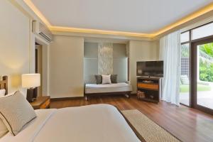 马累Kurumba Maldives的一间卧室配有一张大床和电视