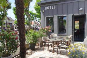 沙特拉永普拉日Boutique Hôtel d'Orbigny Chatelaillon - La Rochelle的酒店前方设有带桌椅的庭院。