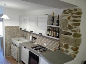 拉泰里纳La Torretta的厨房配有带瓶装葡萄酒的石墙
