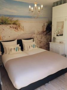 东卡佩勒Bed & Breakfast Zeeduinsepoort的一间卧室配有一张带海滩绘画的床