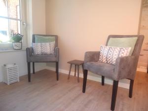东卡佩勒Bed & Breakfast Zeeduinsepoort的房间里的两张椅子和一张桌子