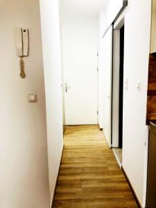 林茨LINZ bellavista Studio-Apartment Landstraße的一间公寓的走廊,拥有白色的墙壁和木地板