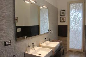 费兰迪纳Le Antiche Vie的一间带两个盥洗盆和大镜子的浴室