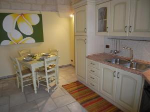 新福卡Casa Nina by RENTHOUSESALENTO - a 50 m dal mare的厨房配有小桌子和水槽