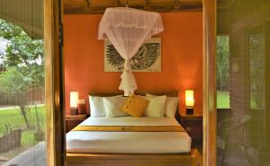 锡吉里亚库维拉生态酒店的一间卧室配有一张橙色墙壁的床