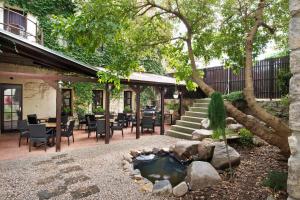 扎泰茨扎泰茨U哈达酒店的一个带池塘、树和椅子的庭院