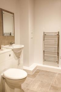 泰恩河畔纽卡斯尔Luxury Apartments Newcastle的白色的浴室设有卫生间和水槽。