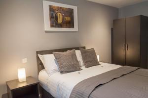 泰恩河畔纽卡斯尔Luxury Apartments Newcastle的一间卧室配有一张带两盏灯的床。