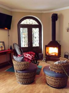 梅斯蒂亚Family Hotel Kala的客厅设有壁炉、柳条搁脚凳和壁炉