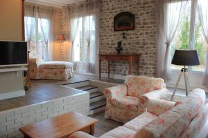 Ã‰tainhusGîte Le Bon Normand的客厅配有沙发、椅子和壁炉