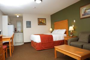 埃德蒙顿城堡汽车旅馆的酒店客房配有床、沙发和桌子。