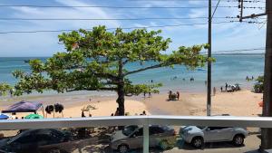 安谢塔Apartamento 3 quartos Beira Mar的一片种着树的海滩和水中的人