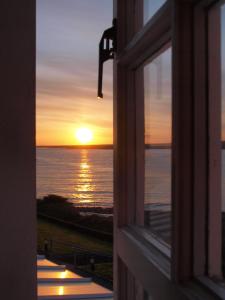 巴利卡斯尔Stella Maris Shore House的从日落的窗口欣赏美景