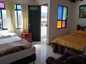 瓜塔佩El Nuevo Mirador的一间卧室设有两张床和彩色玻璃窗。