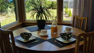纳尔逊Morning Bloom Cottage Bed and Breakfast的一张木桌,放上两杯和一瓶橙汁