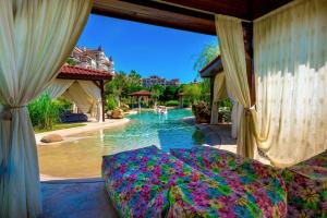 内塞伯尔Poseidon VIP Residence Club Balneo & SPA Resort的一间卧室,配有一张位于游泳池旁的床